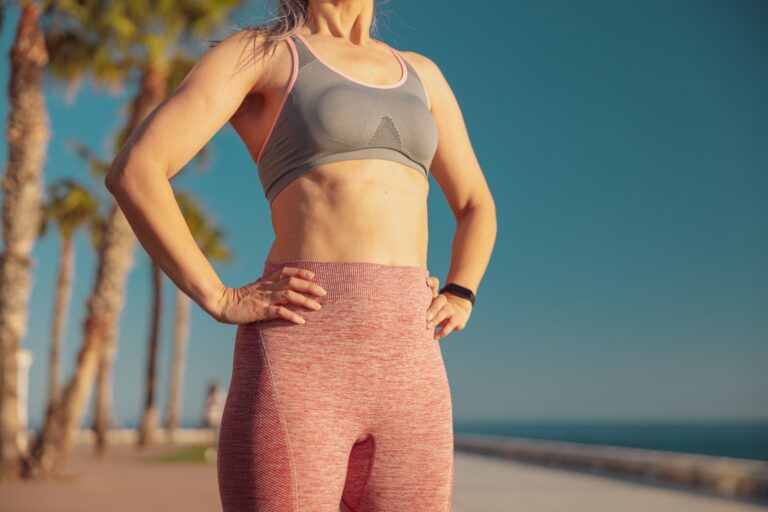 Traitement anti-cellulite à Nice : femme sportive à la peau ferme du ventre et des cuisses au bord de mer